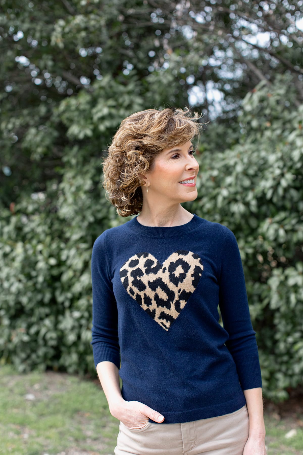 woman in heart sweater looking towards her left