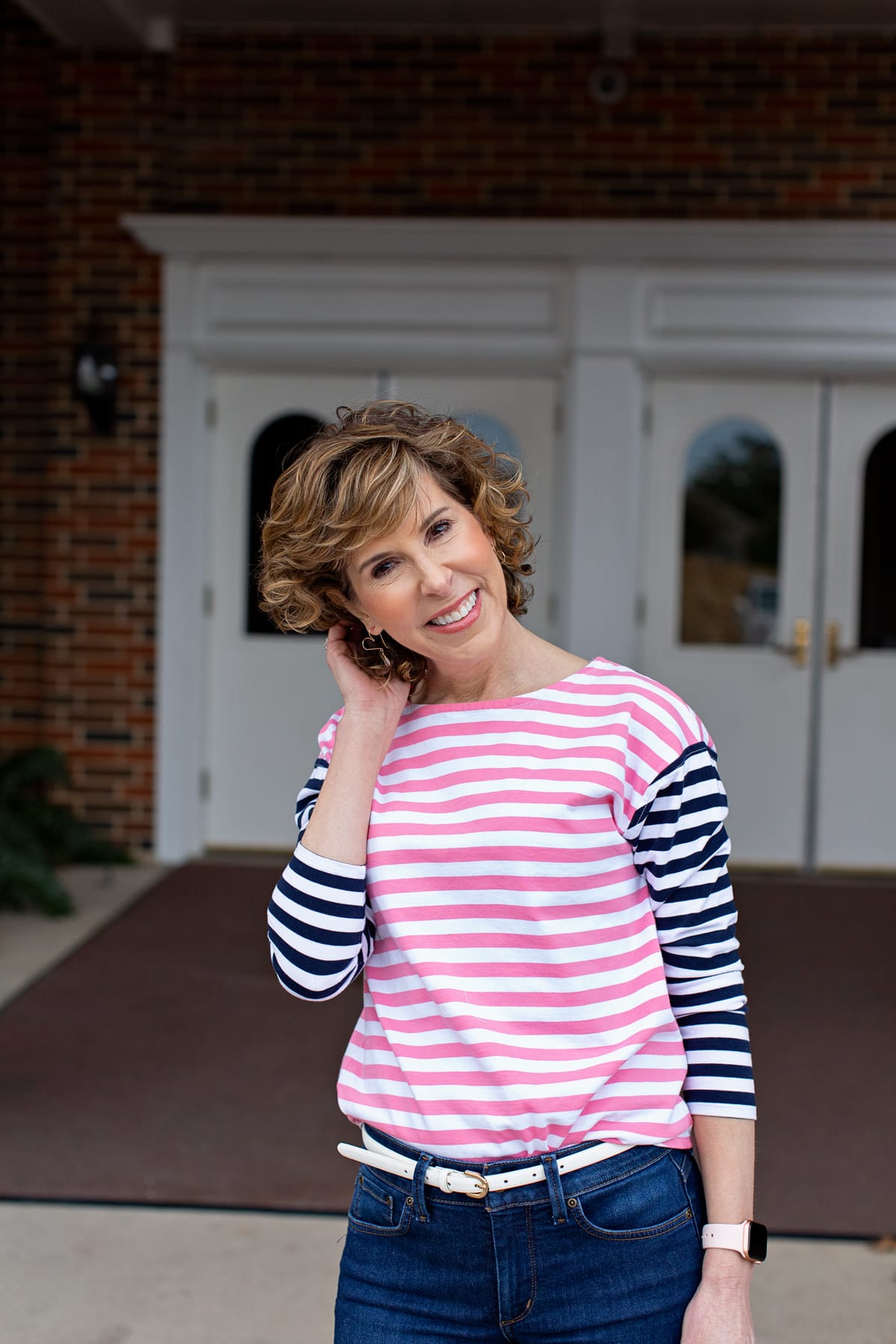 woman wearing striped shirt standing in front of white doors