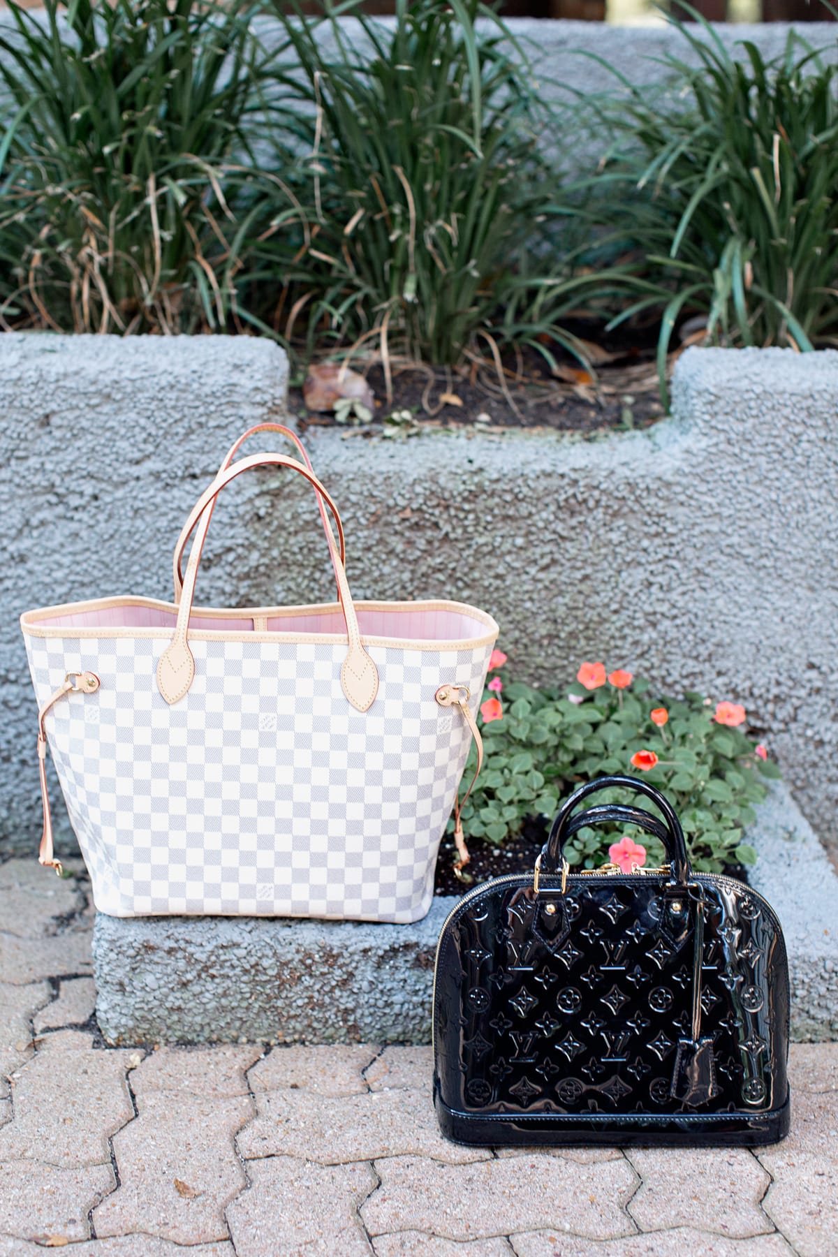 two designer handbags sitting on the ground