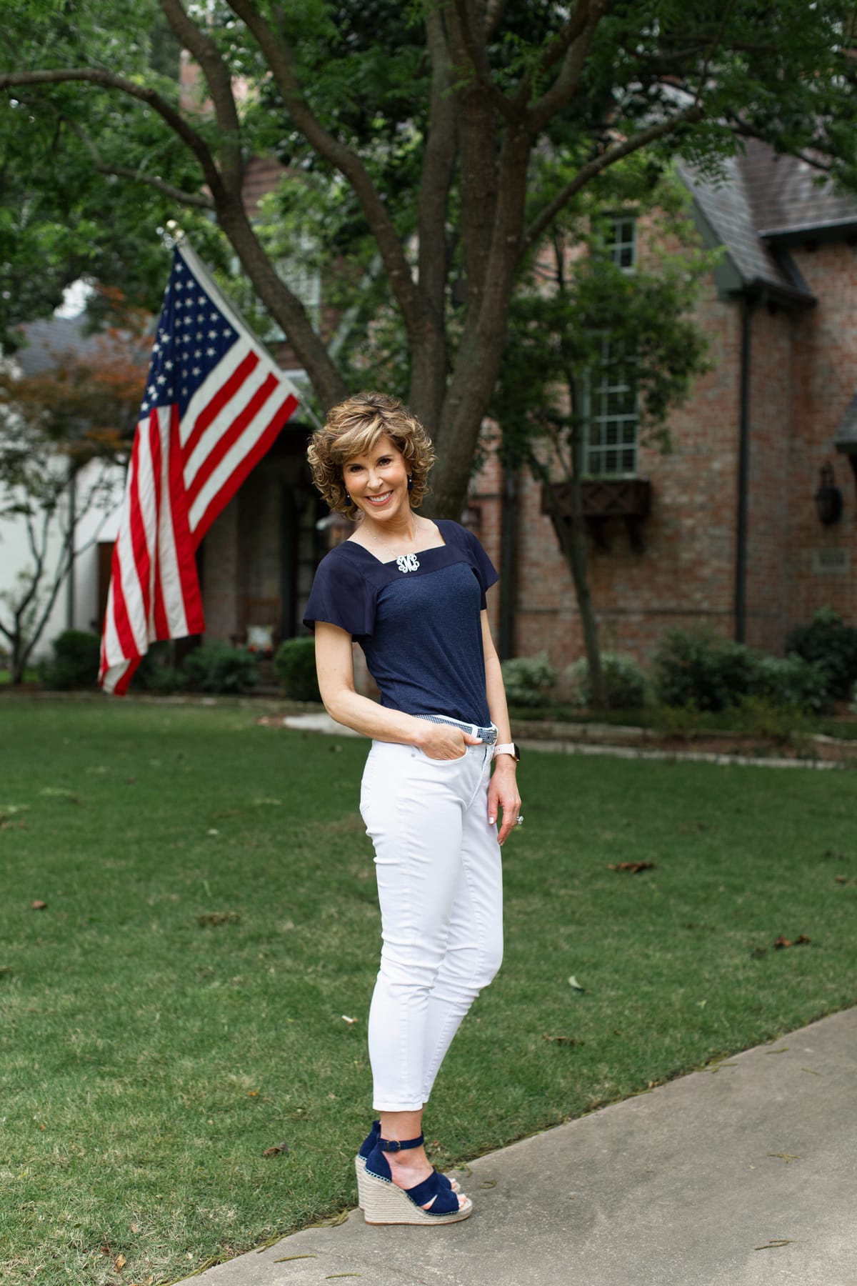 woman standing in front yard with flag