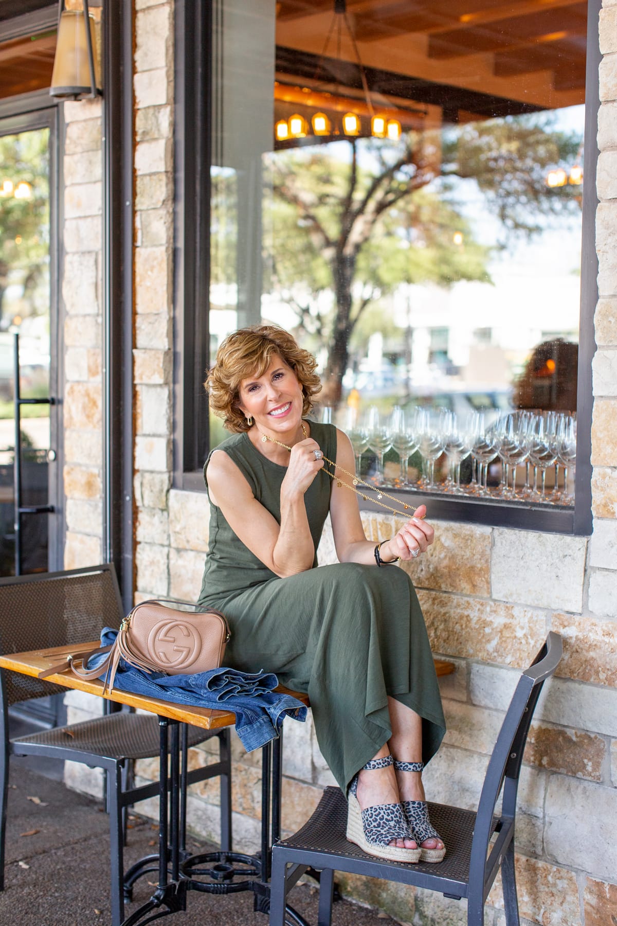 woman in green dress sitting at a restaurant patio table