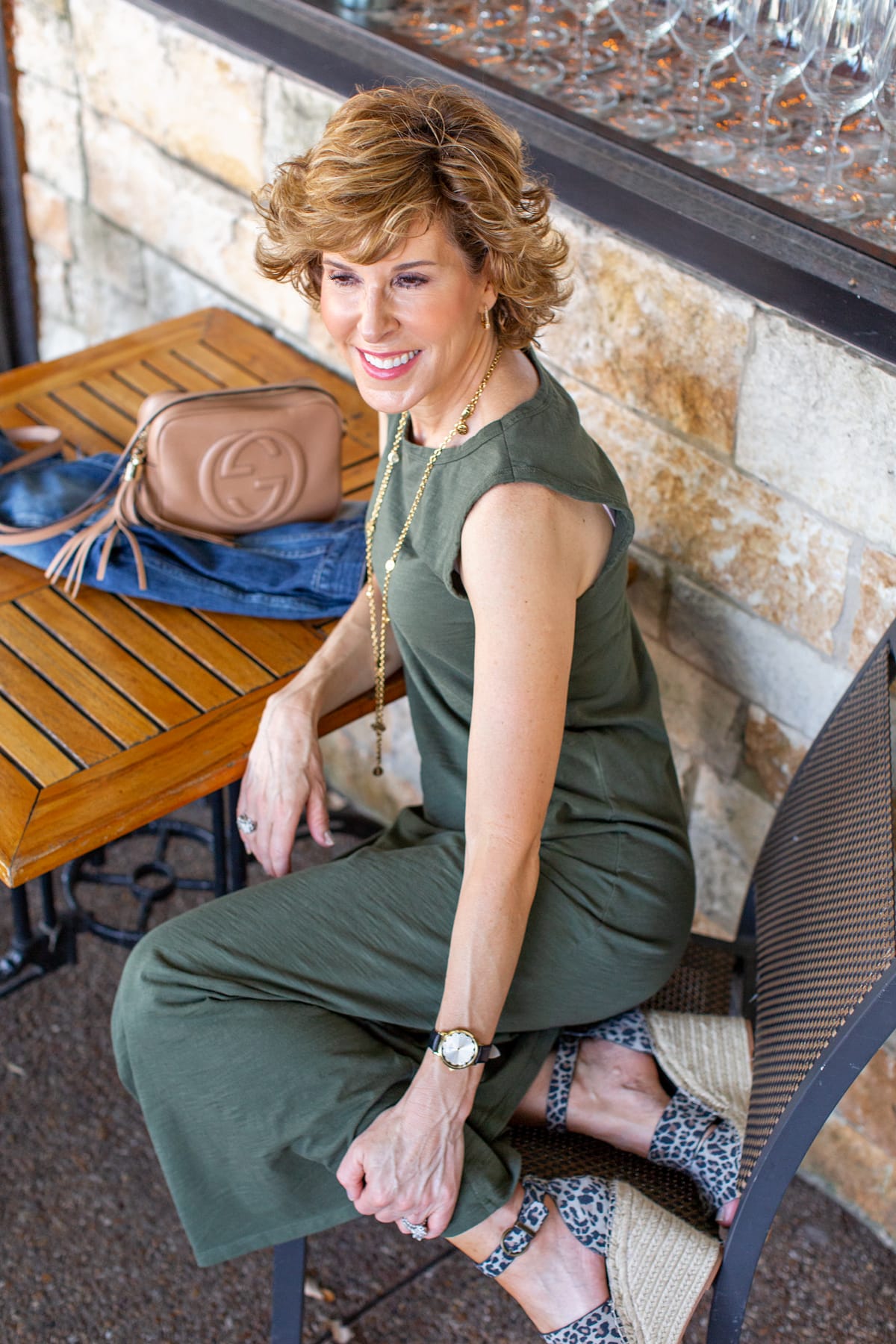 woman in green dress sitting at a restaurant patio table