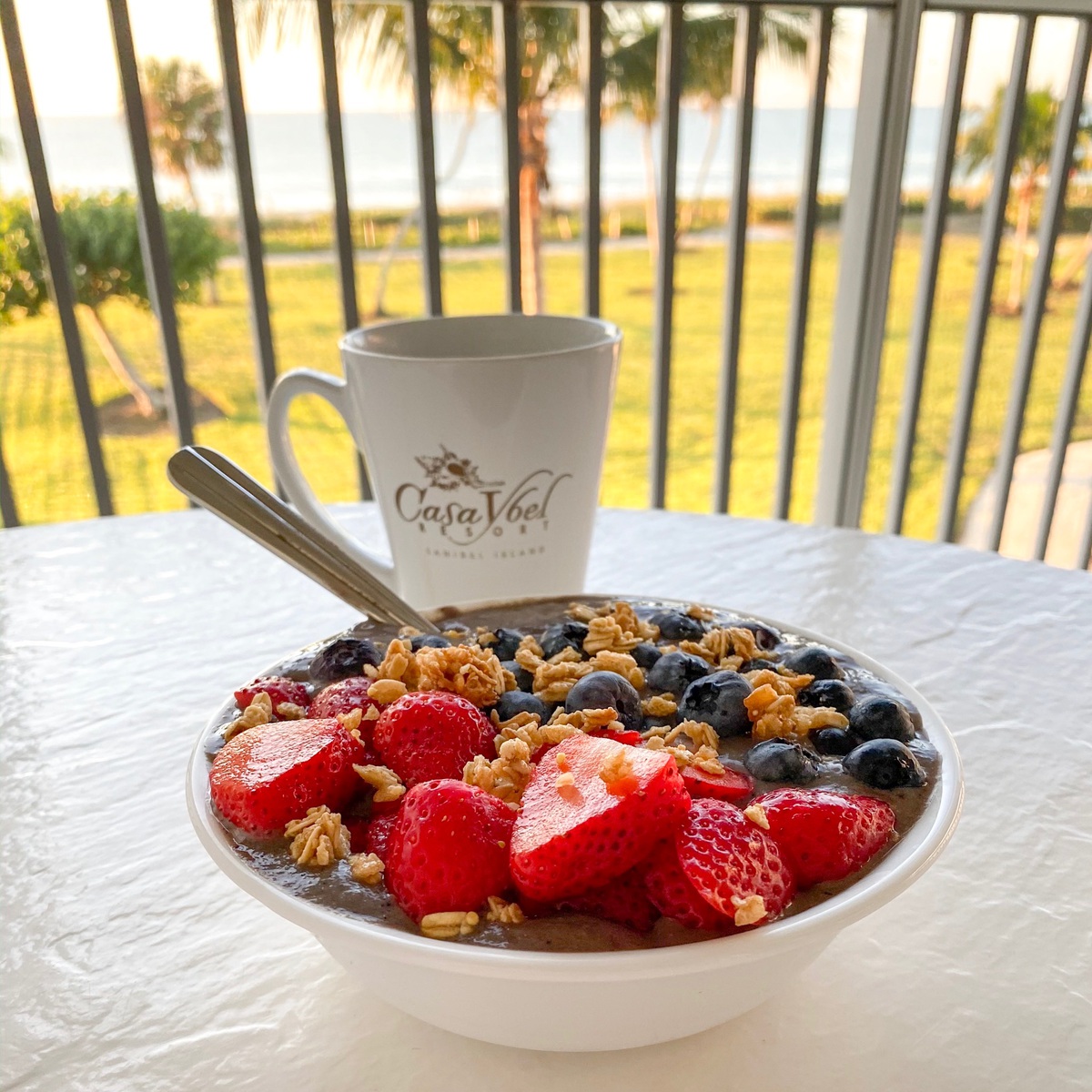 acai bowl on white table overlooking beach