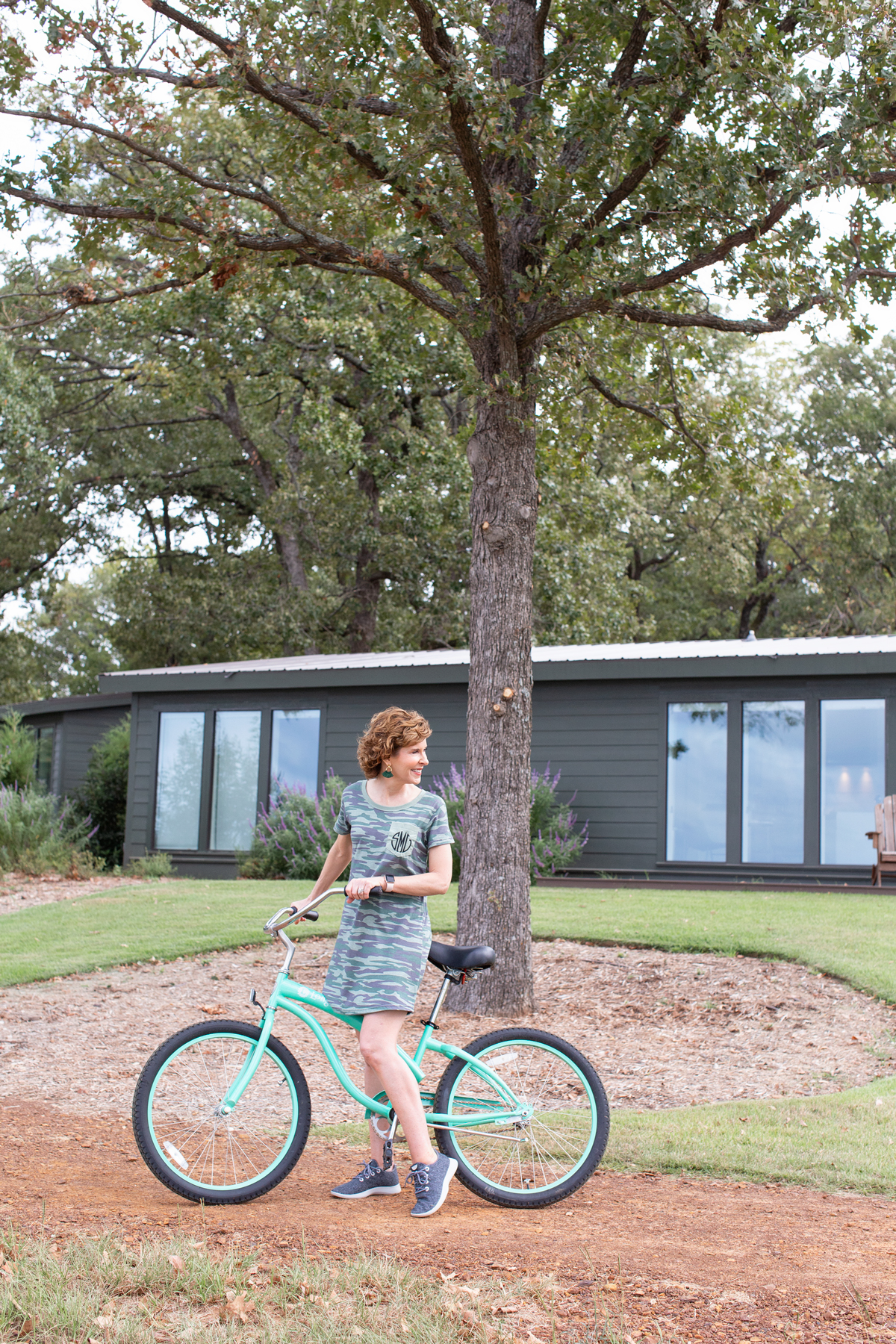 woman wearing camo dress riding a bike