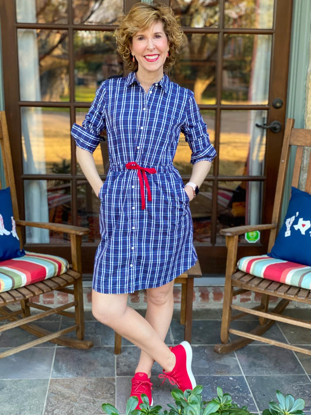 woman in blue dress with red shoes standing on her front porch