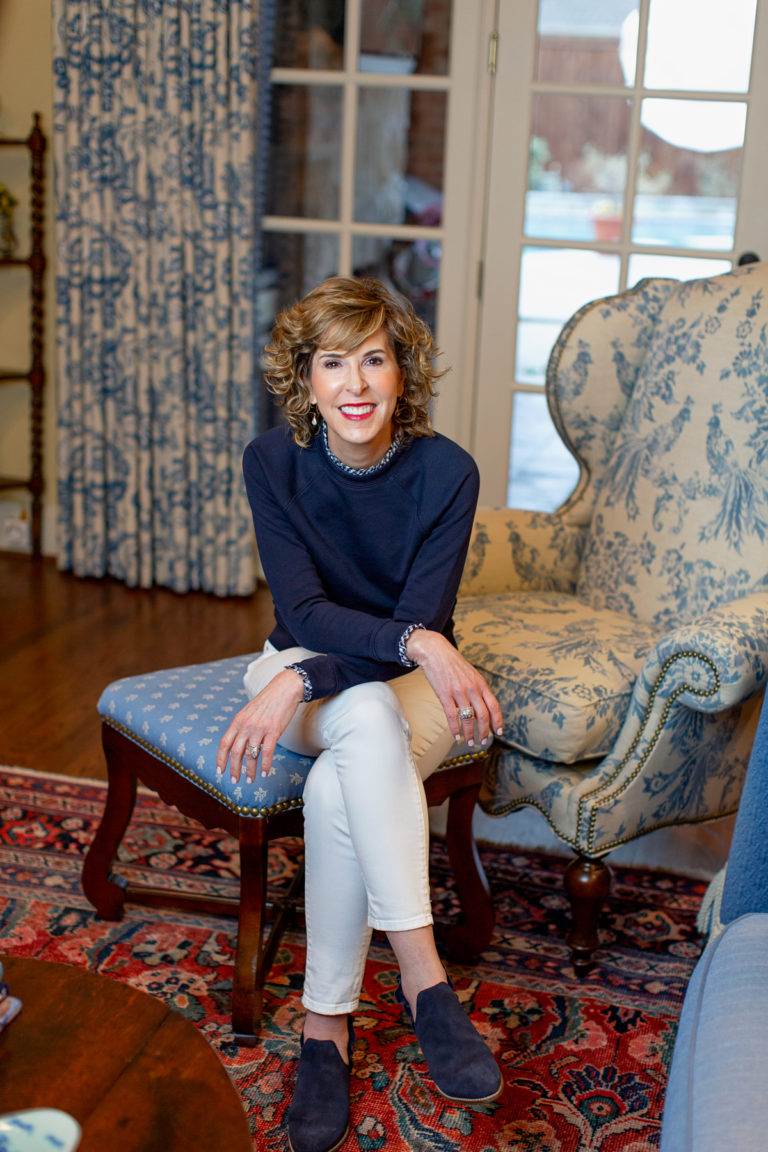 woman sitting on ottoman in blue and white room