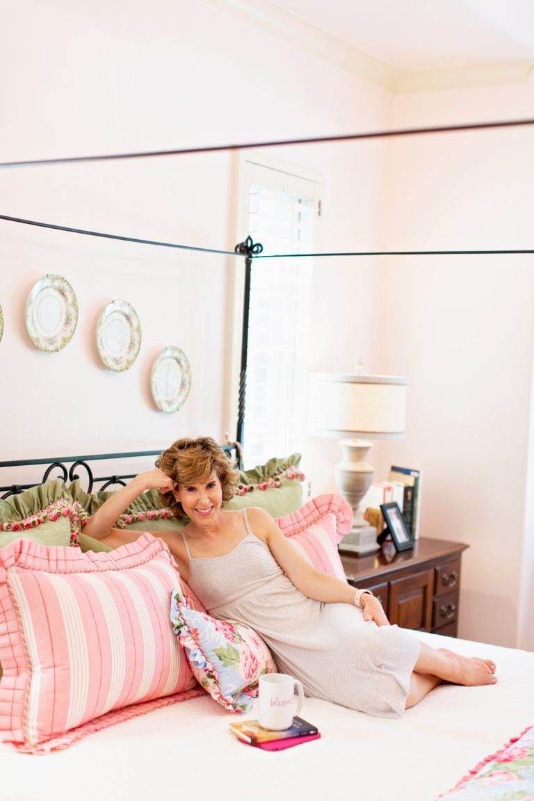 woman in nightgown on her bed looking at camera