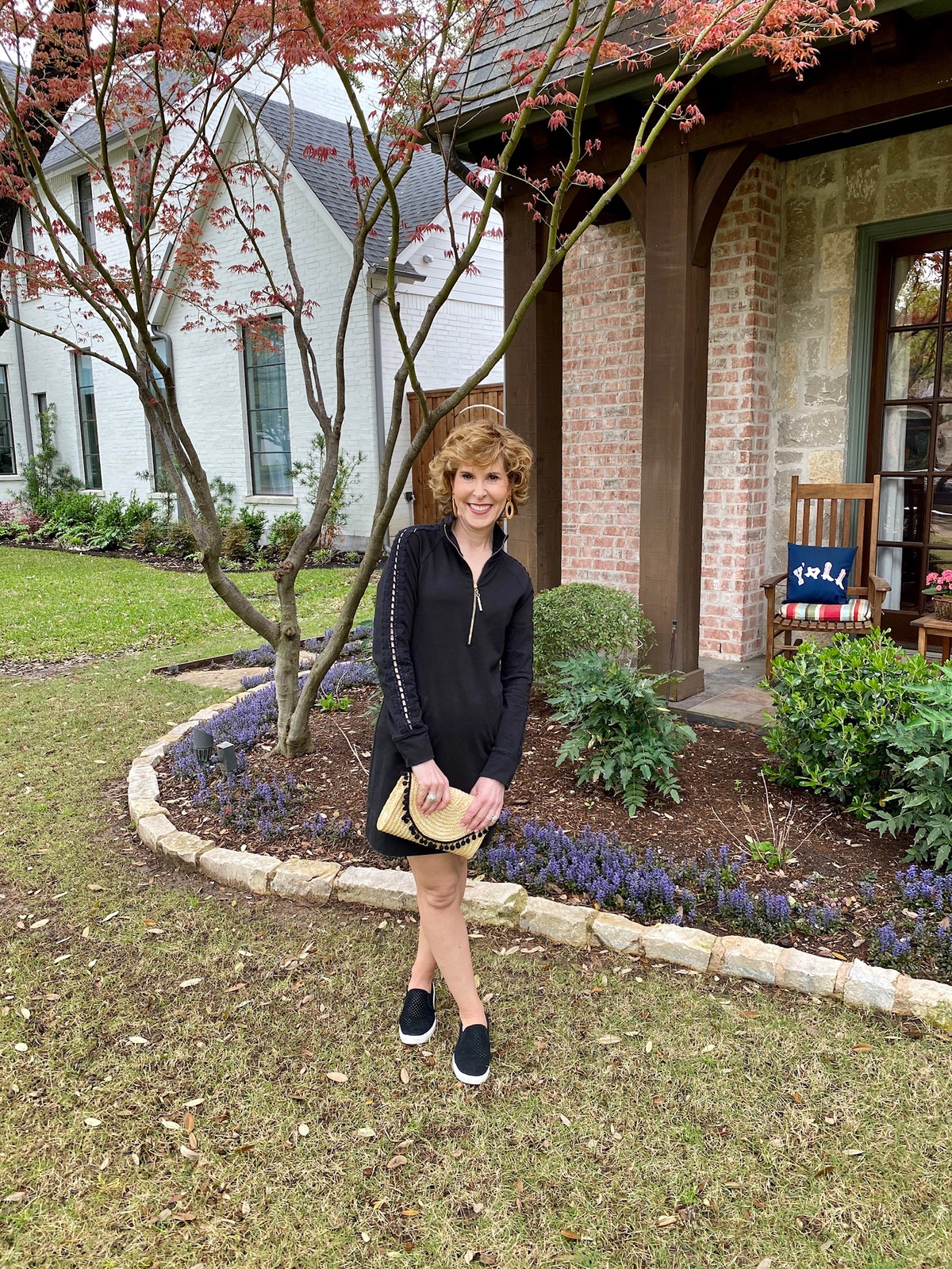 woman in black dress standing in her front yard