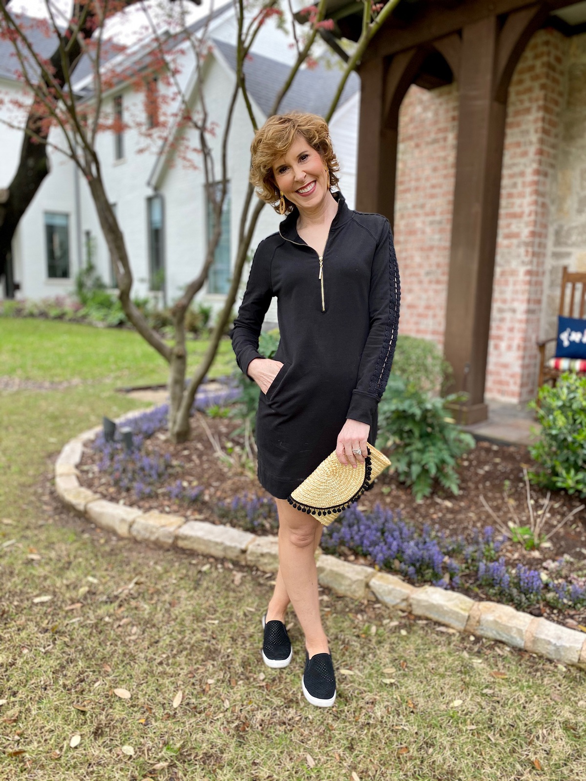 woman in black dress standing in her front yard