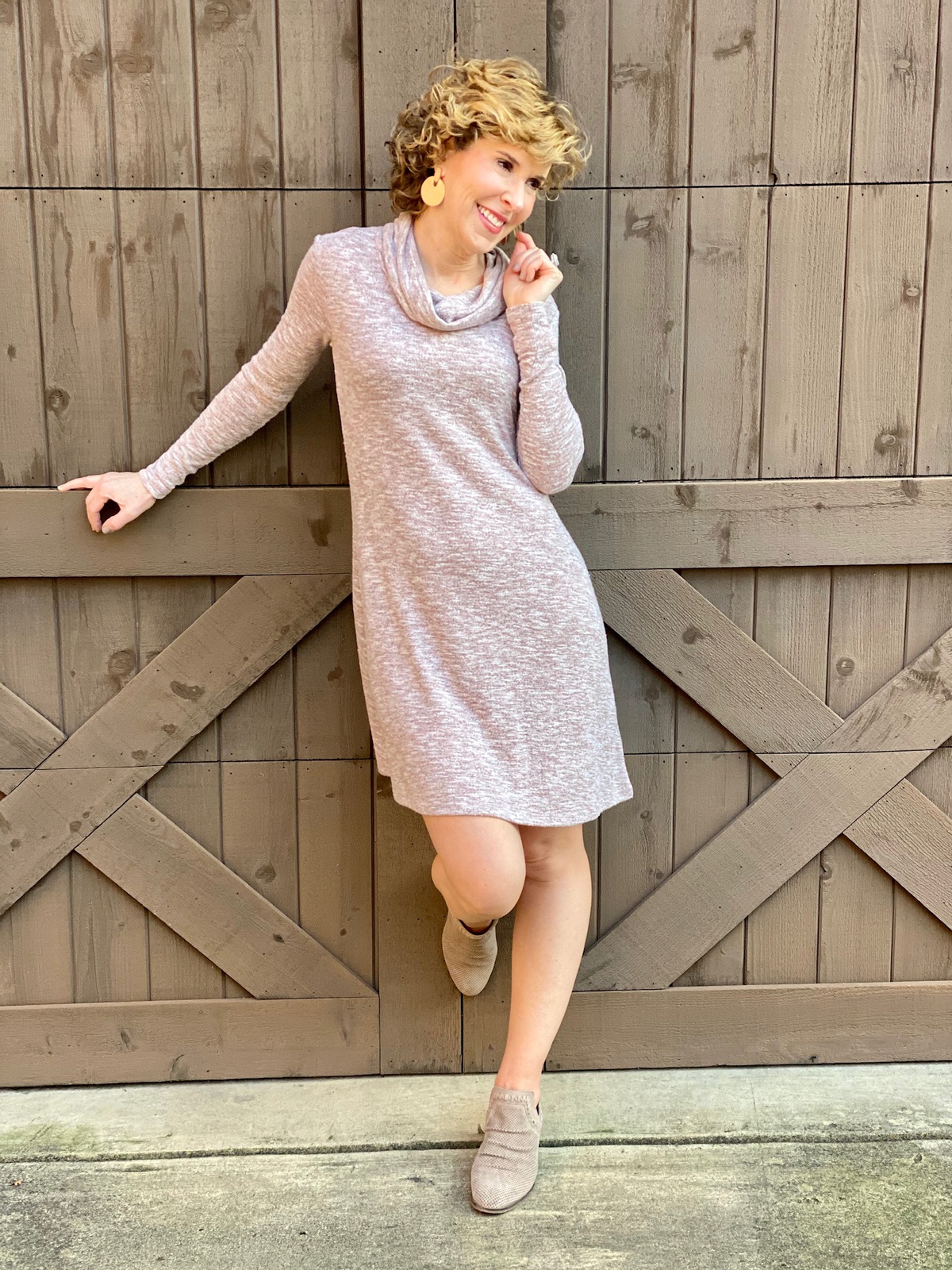 woman over 50 wearing rose gold tunic dress