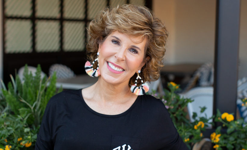 woman in black dress with colorful earrings