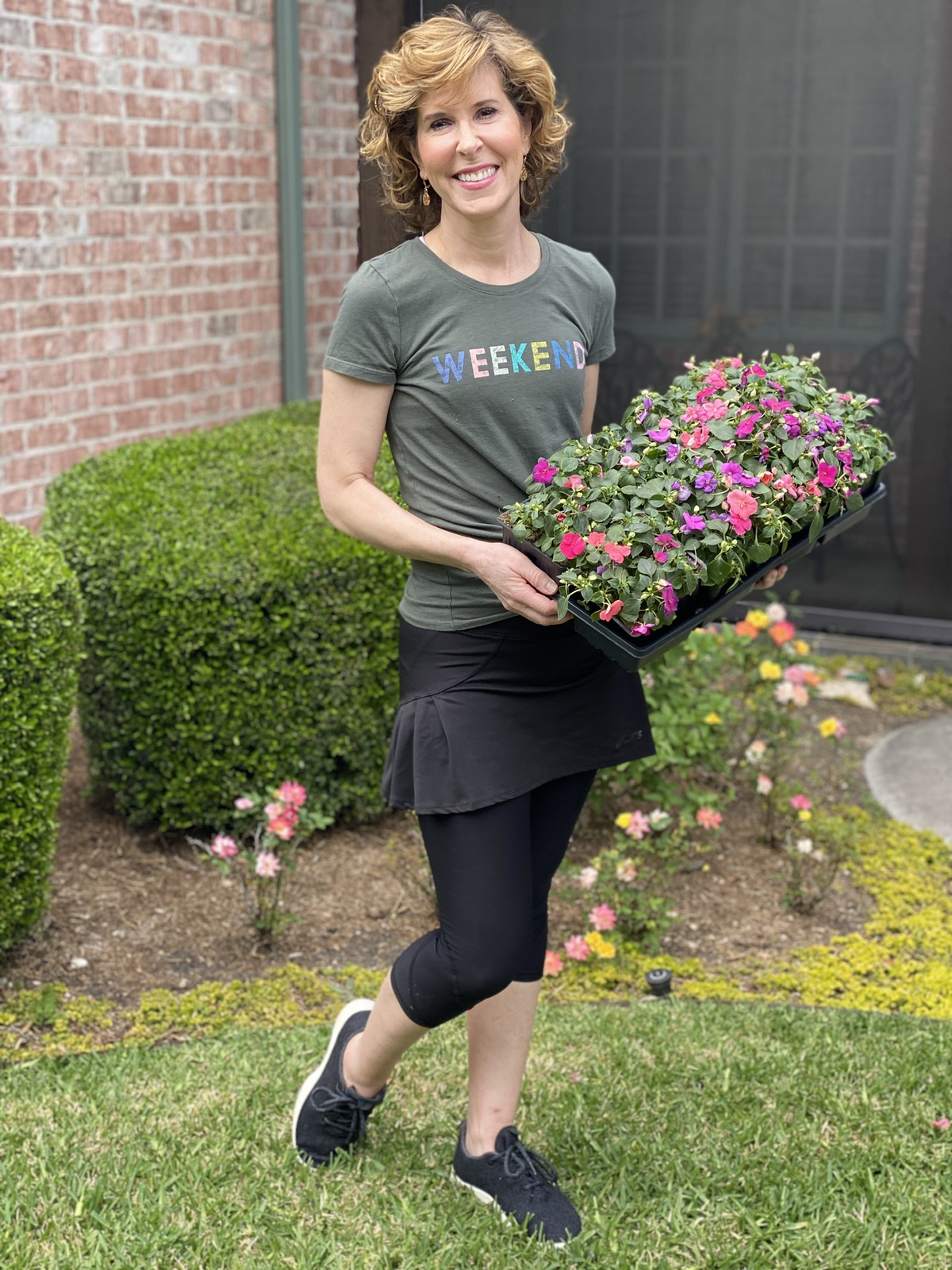 woman carrying flowers to plant