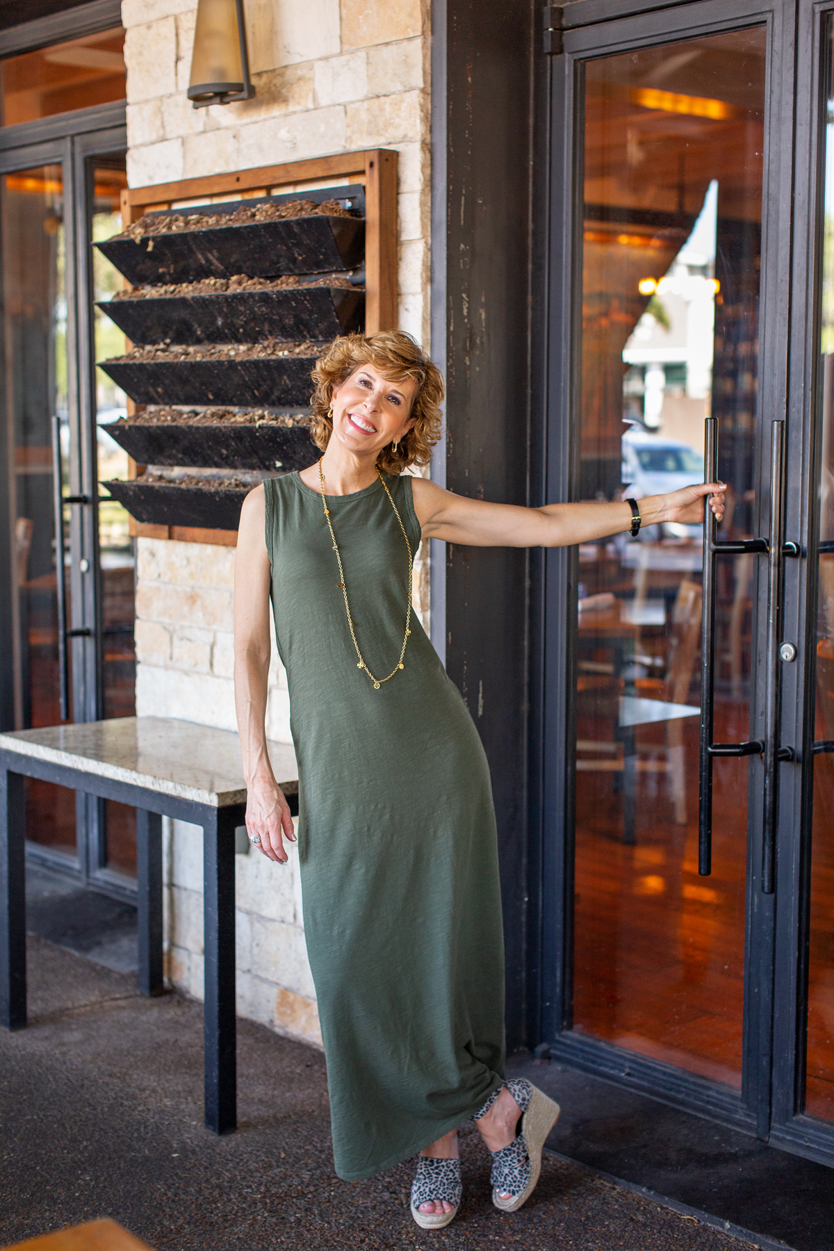 woman in green dress standing by a door