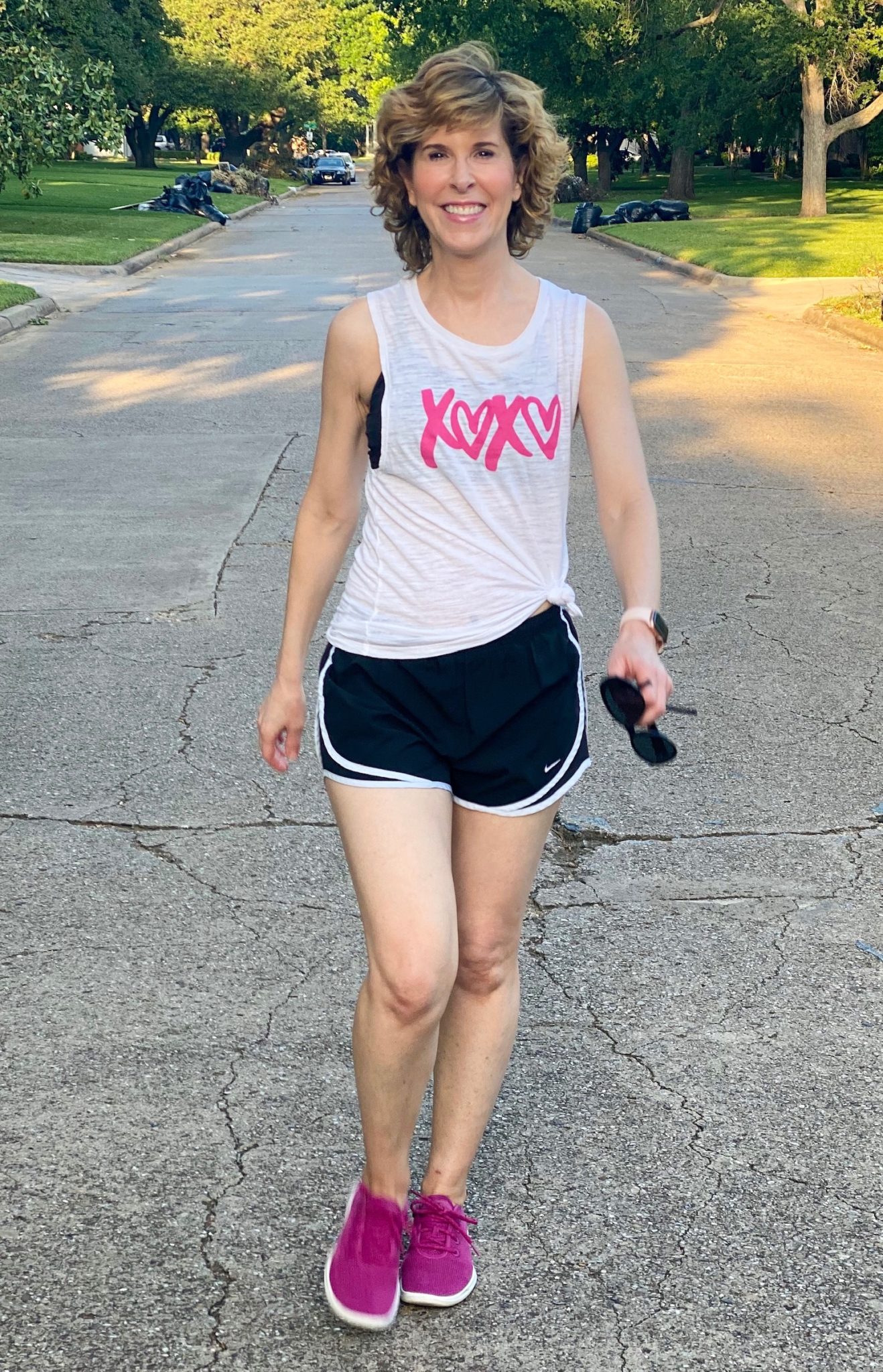 woman wearing grapic xoxo tee and exercise shorts walking