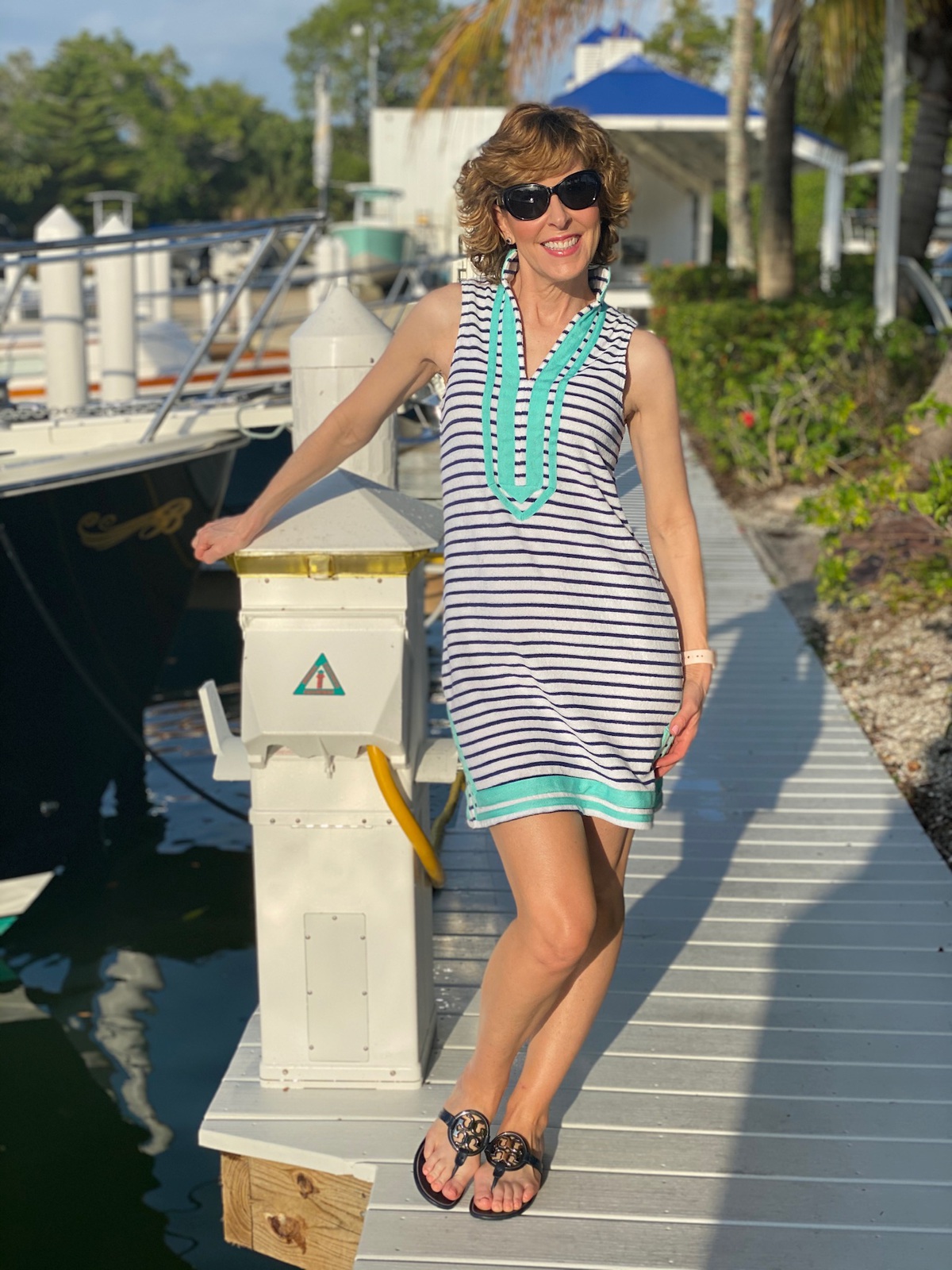 woman in blue and white striped tunic standing on a dock