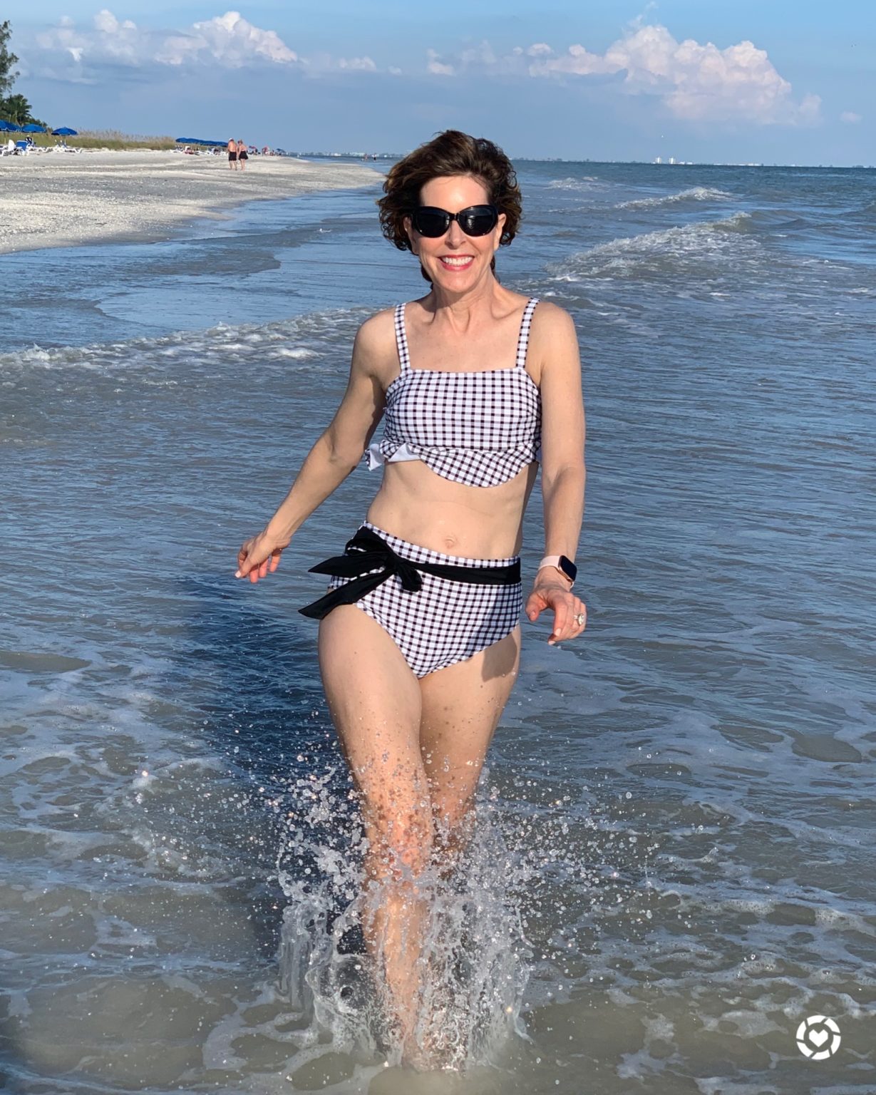 woman in bikini walking through surf