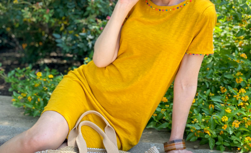 woman wearing boden gold charlie jersey dress sitting on curb by chico's jute tote