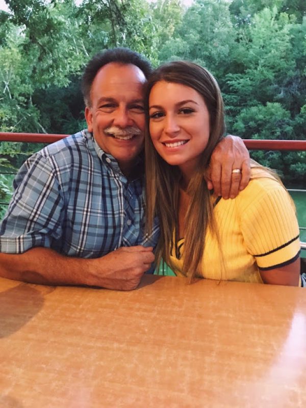 woman dressed in a yellow top posing with her dad