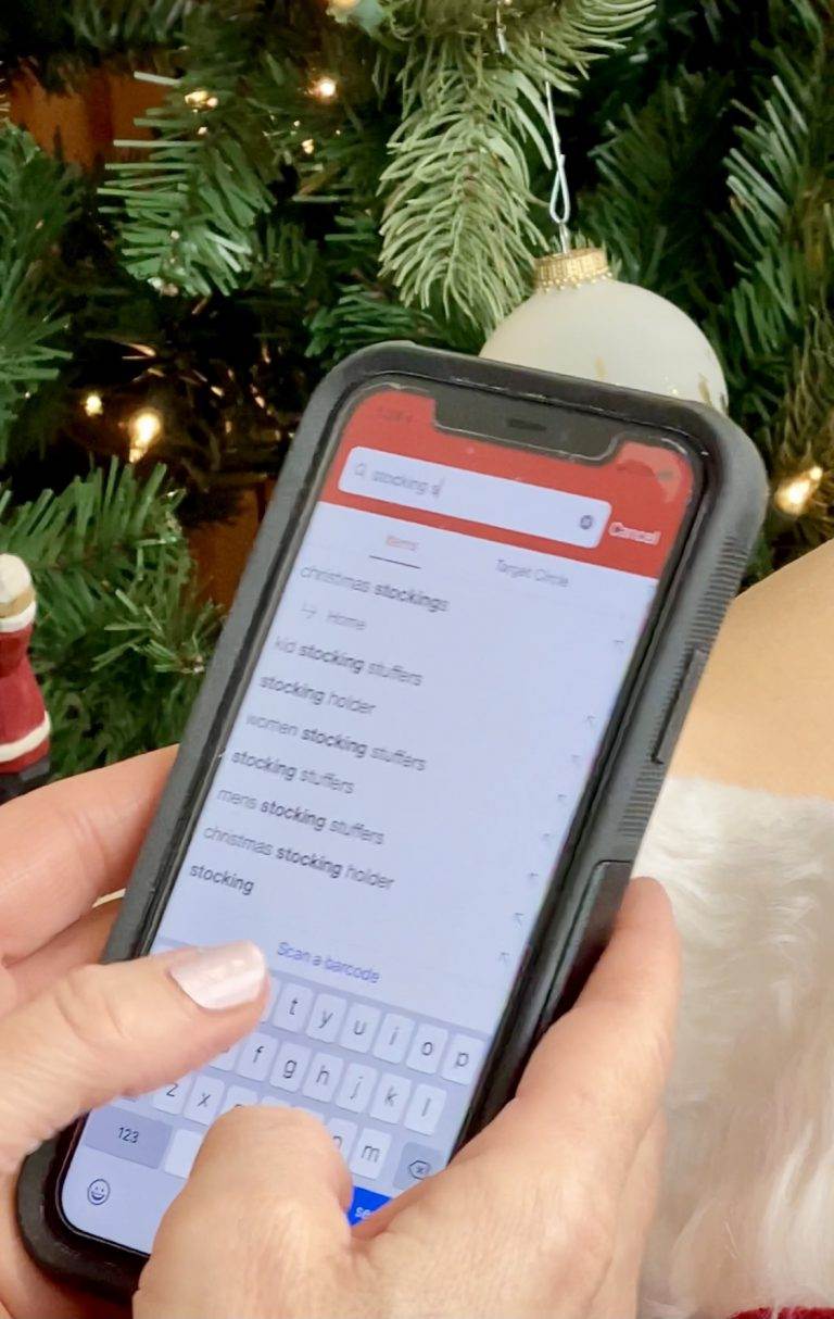 woman safe online shopping on her phone with christmas tree in background