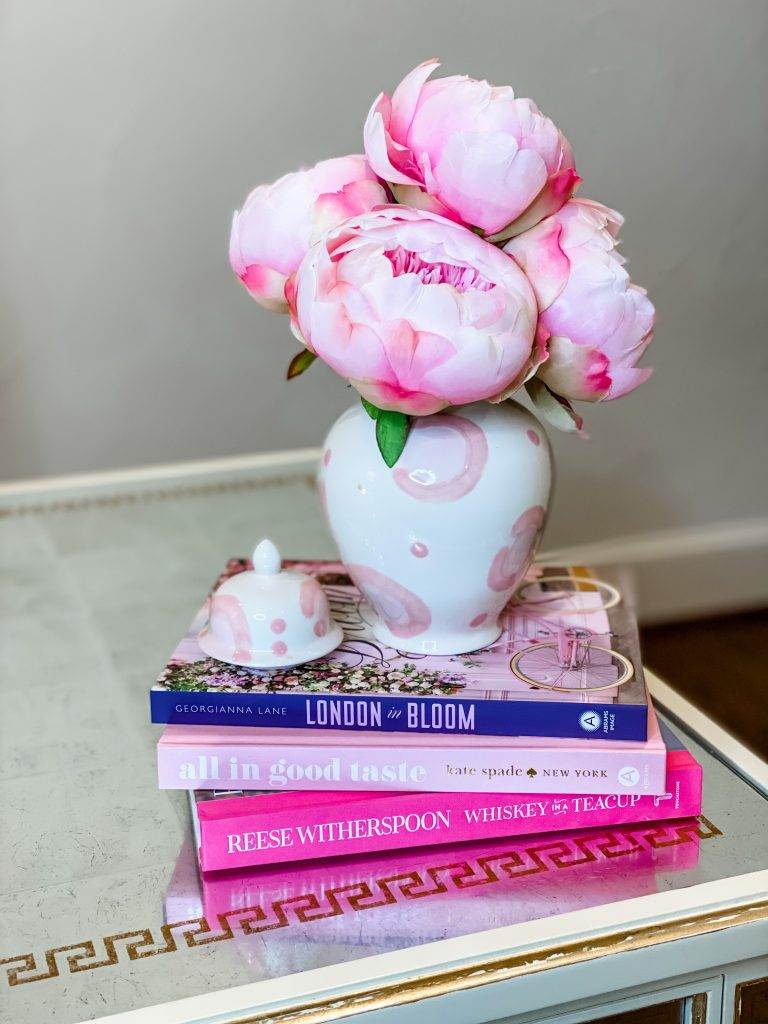 pink coffee table books and pink leopard print ginger jar with silk pink peonies inside