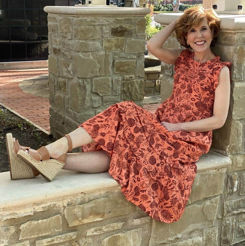 woman sitting on a rock wall wearing Floral Print Ruffle Sleeveless Dress - Universal Thread™