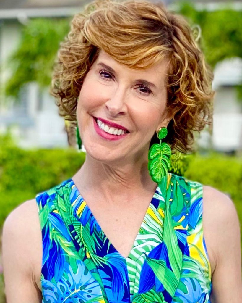 woman over 50 tommy bahama Hot Tropic Maxi Dress and jcrew factory palm earrings posing on a white bridge in a tropical location