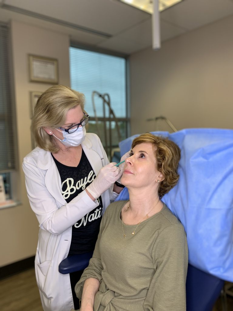 woman over 50 wearing green dress receiving botox injections from dr. lori stetler of dallas center for dermatology and aesthetics