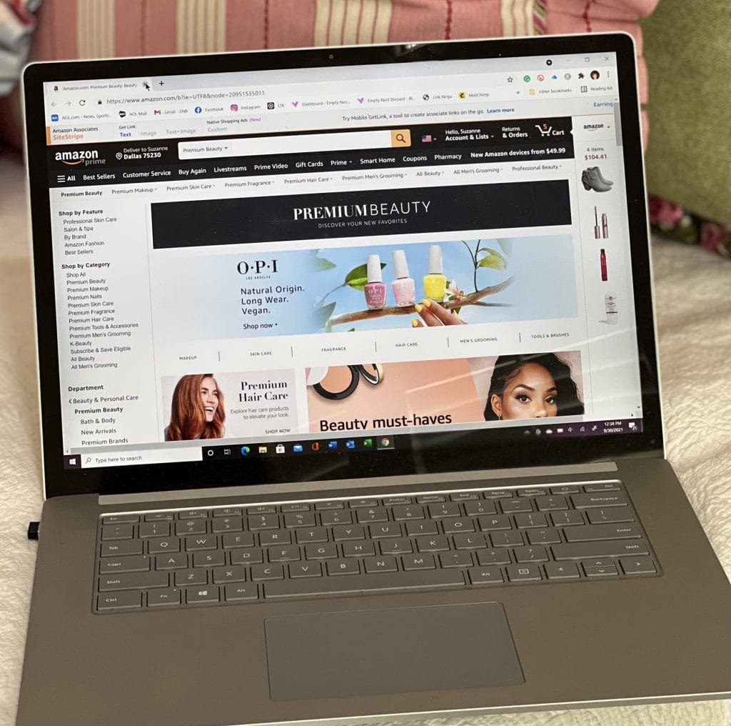 computer sitting on a bed with Amazon beauty page on screen