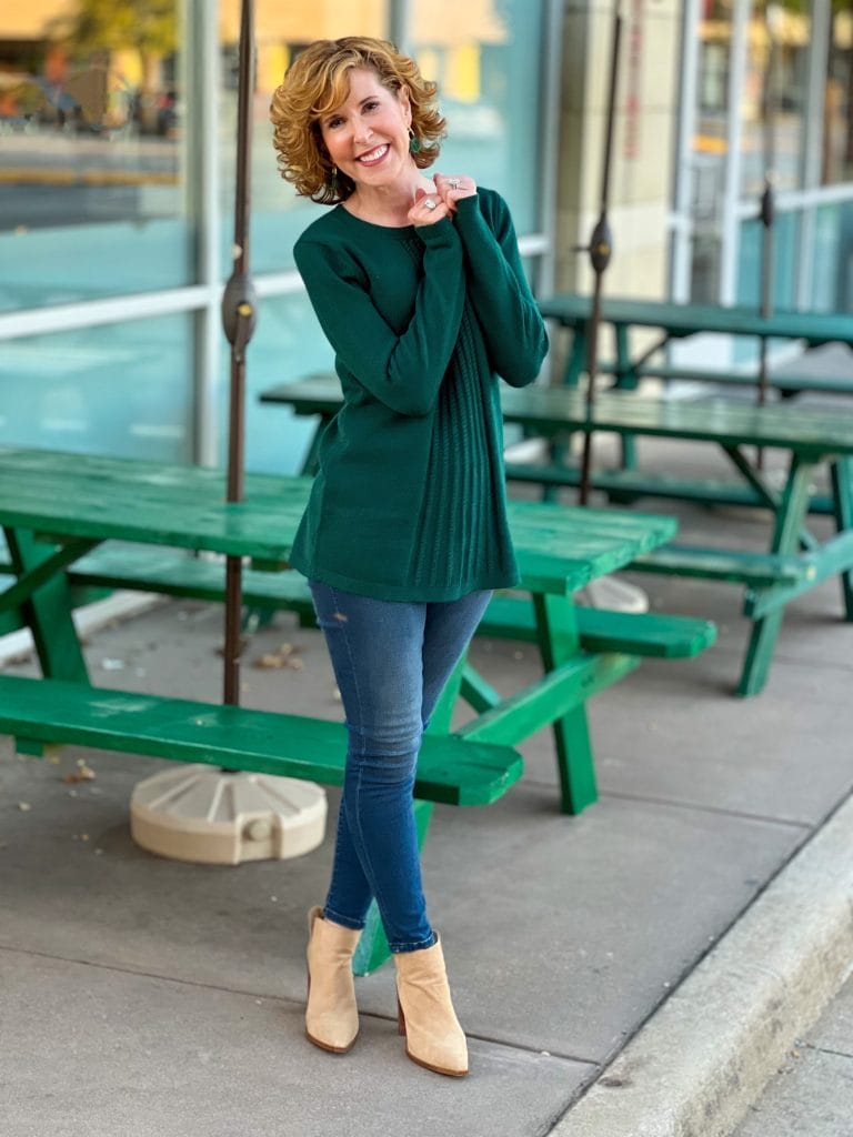 woman standing by green picnic table wearing soft surroundings priscilla pullover tunic sweater and Supremely Soft Relaxed Straight Jeans