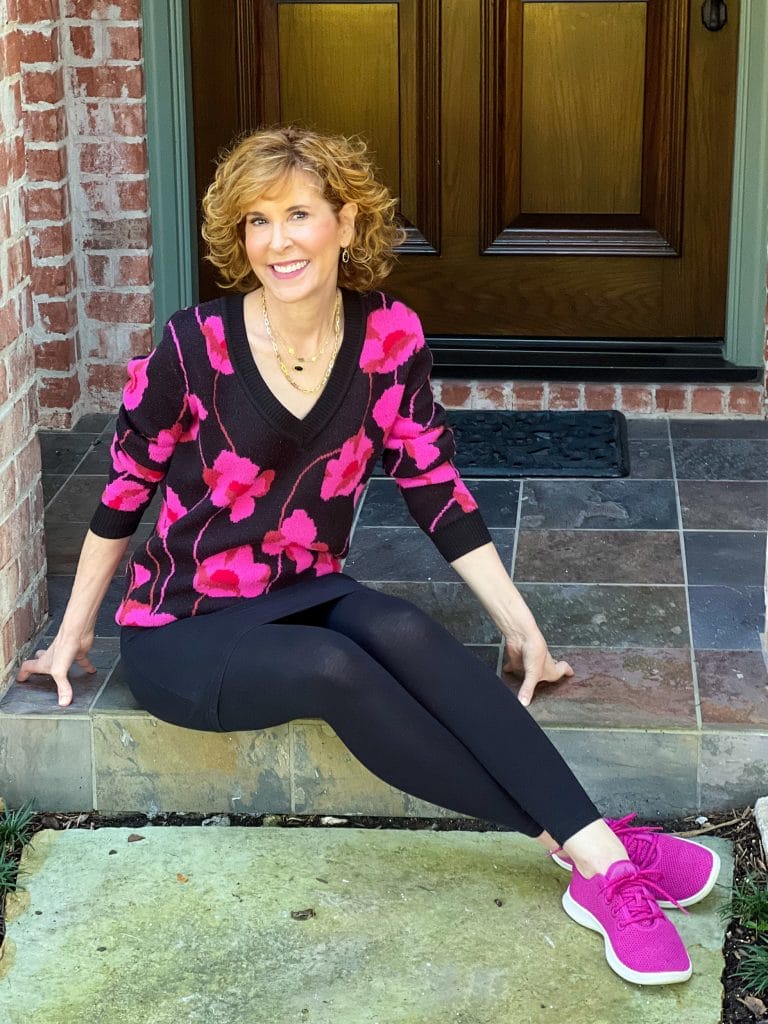 woman on front porch wearing cabi m'leggings and Rococo Pullover with fucshia sneakers