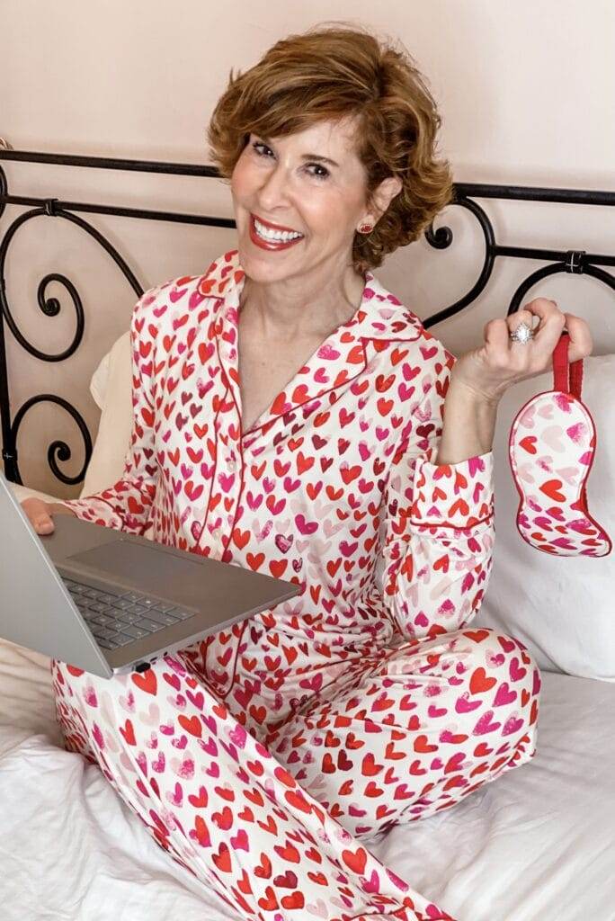 woman wearing heart pajamas and sitting in her bed