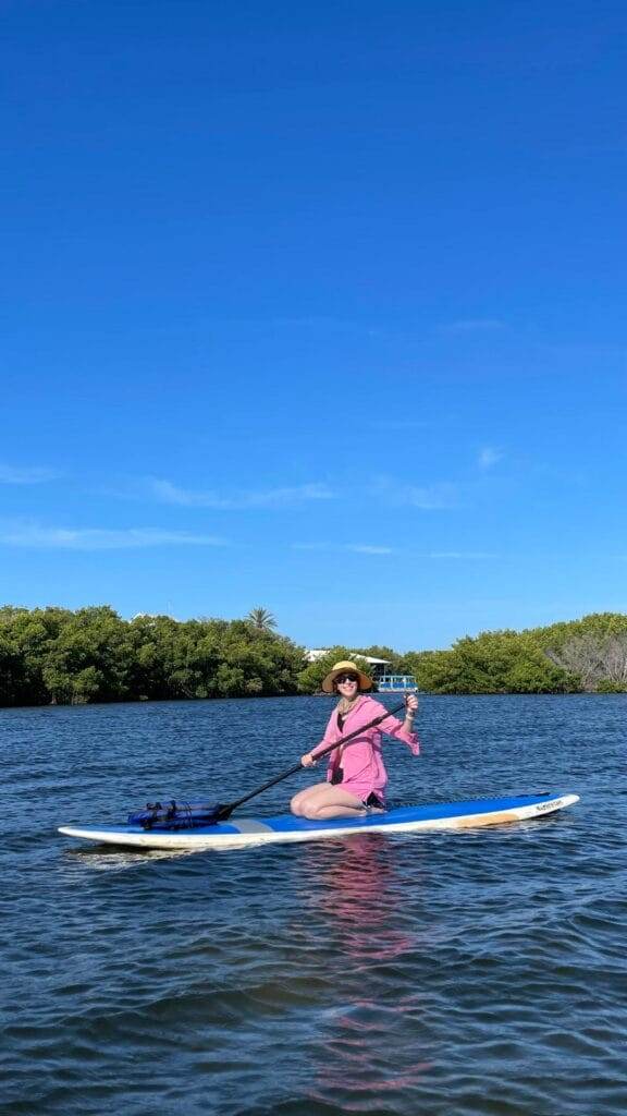 woman in pink sun shirt paddleboarding