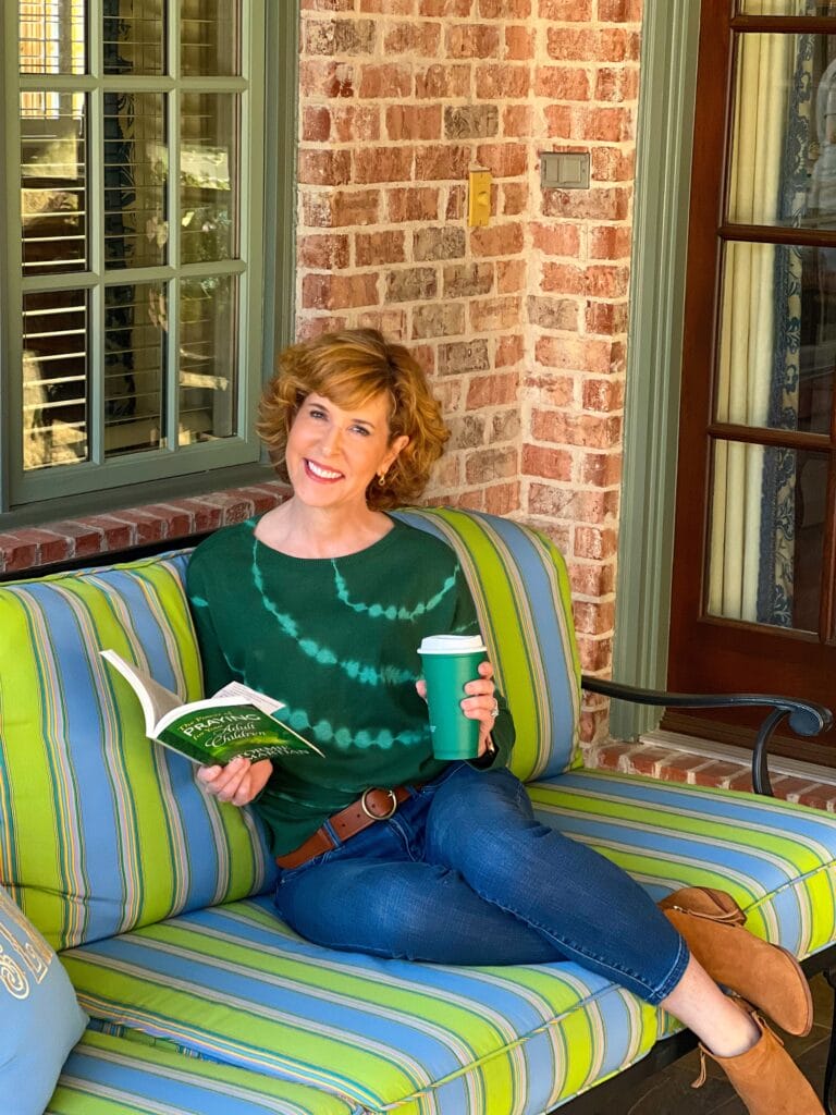 woman over 50 wearing jjill reading on a sofa
