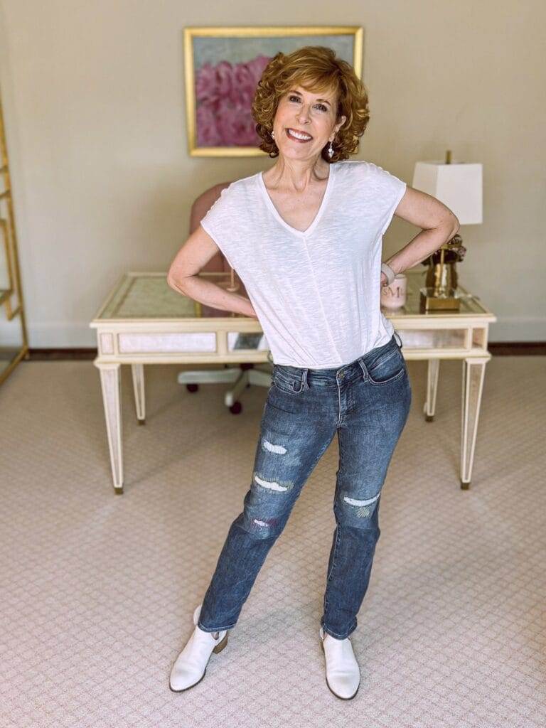woman over 50 wearing whbm white jetsetter tee and nydj Marilyn Straight Ankle Jeans standing in front of an office desk
