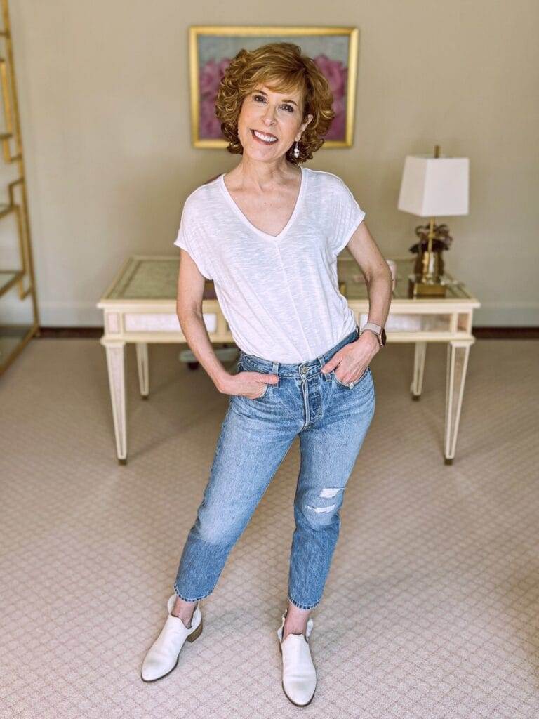 woman over 50 wearing whbm white jetsetter tee and levis button fly distressed boyfriend jeans