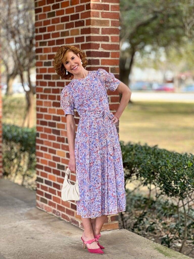 woman over 50 wearing Chelsea28 Floral Puff Sleeve Midi Dress from Nordstrom leaning against a brick wall