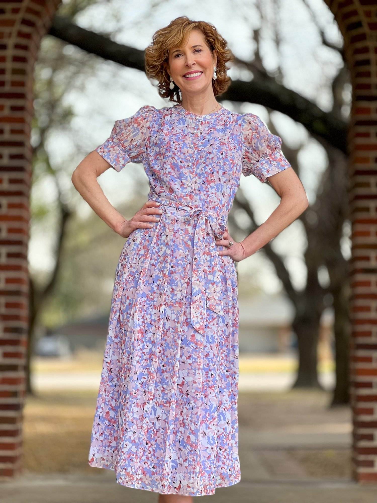 woman over 50 wearing Chelsea28 Floral Puff Sleeve Midi Dress from Nordstrom leaning against a brick wall