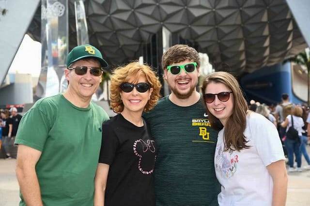 4 adutls standing in front of the ball at Epcot