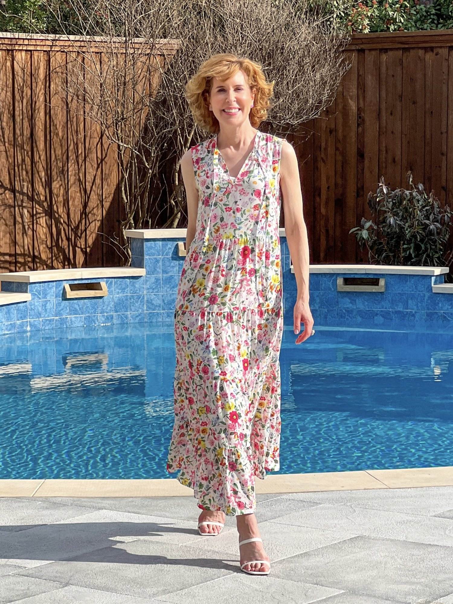 woman walking by a swimming pool wearing Caslon Floral Print Sleeveless Maxi Dress from Nordstrom getting ready for answering your questions