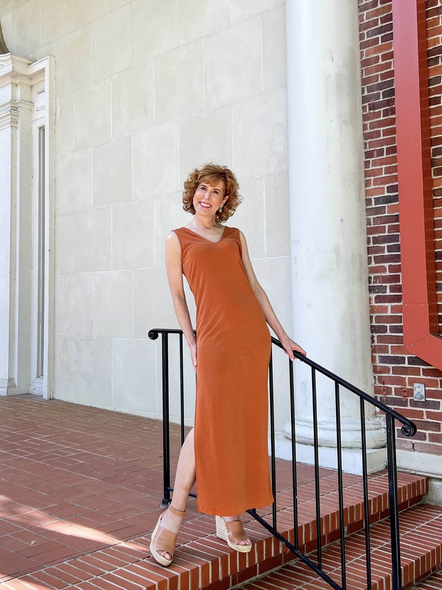 woman posing by a black bannister and white wall wearing nordstrom made brand open edit