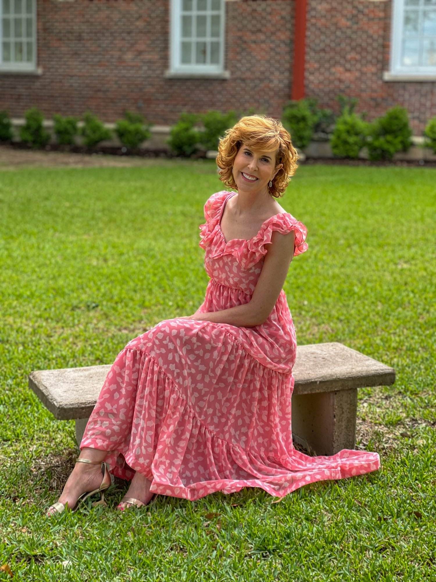 woman over 50 wearing Chelsea28 Ruffle Midi Dress from Nordstrom sitting on a bench