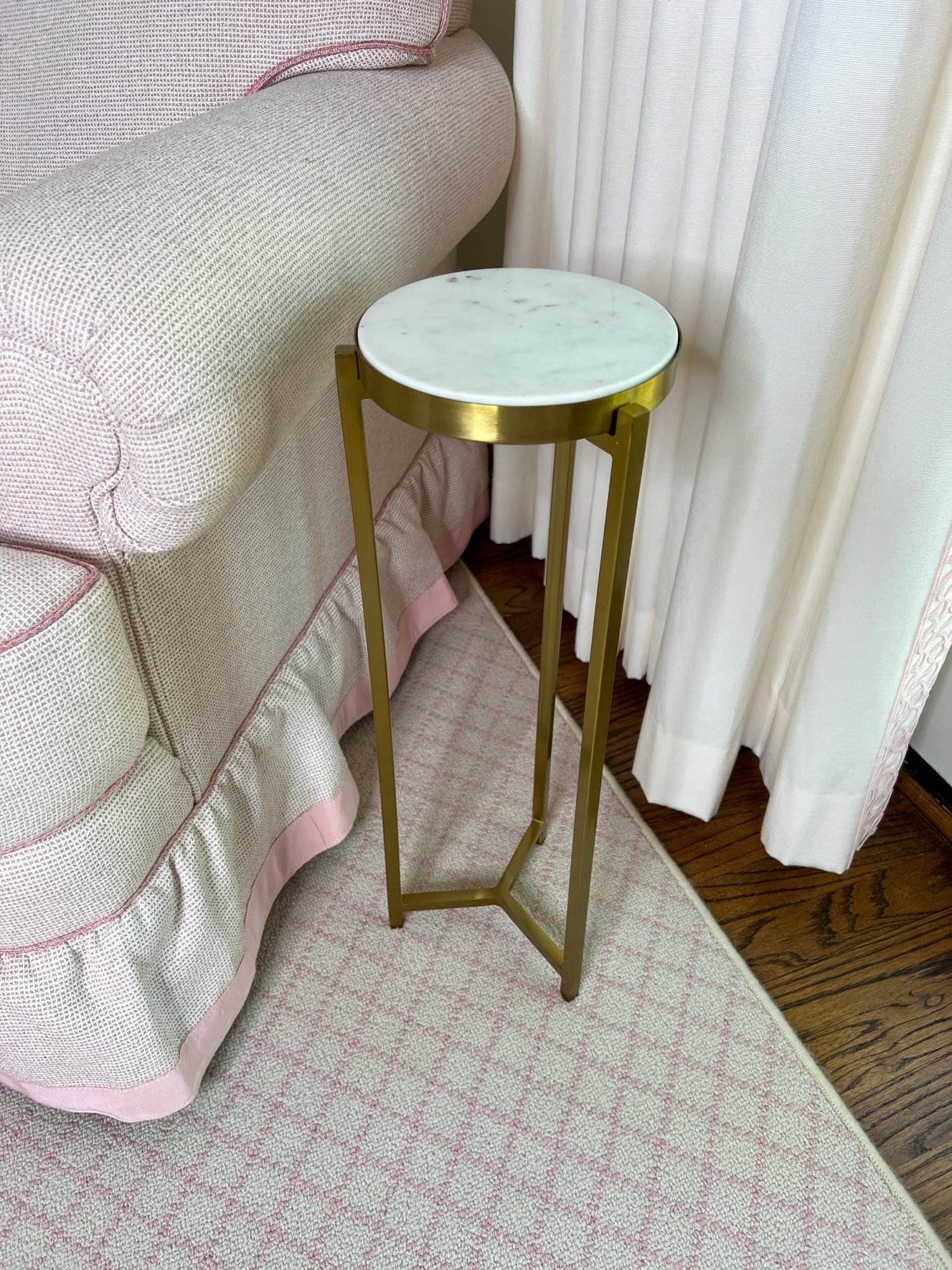 white marble top martini table beside pale pink club chair