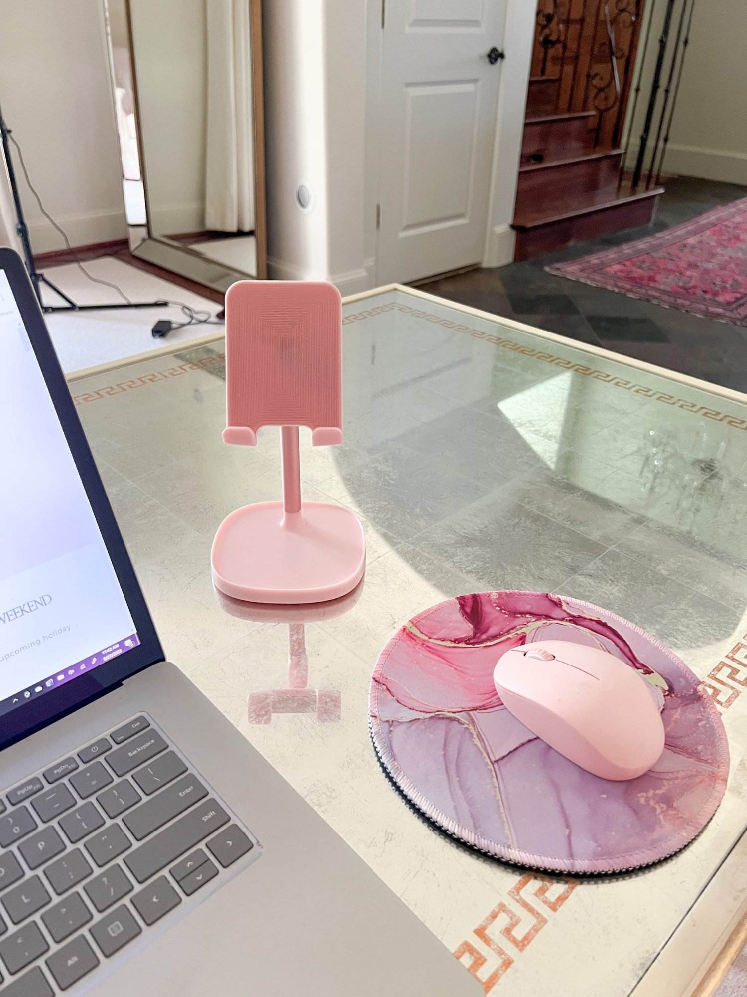 pink phone stand and pink mouse on pink marble mousepad on mirrored desk