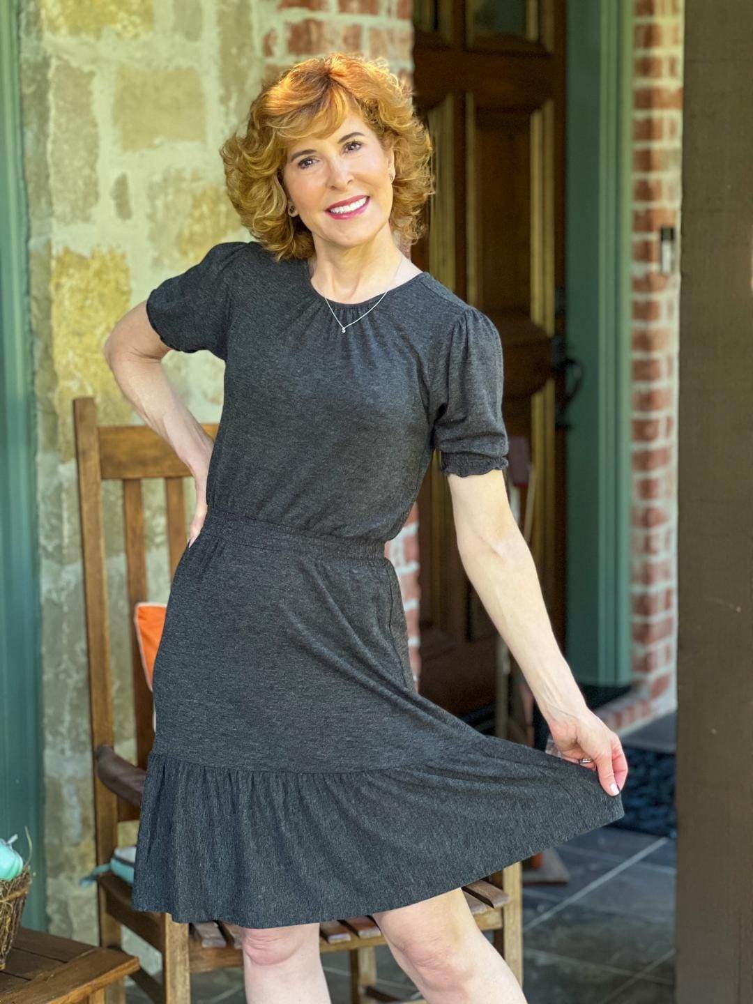 woman stading on a porch wearing loft gray smocked flounce dress