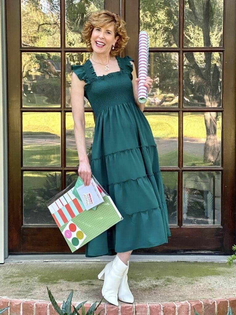 woman wearing green hillhouse home dress holding gift wrapping products from joy creative shop