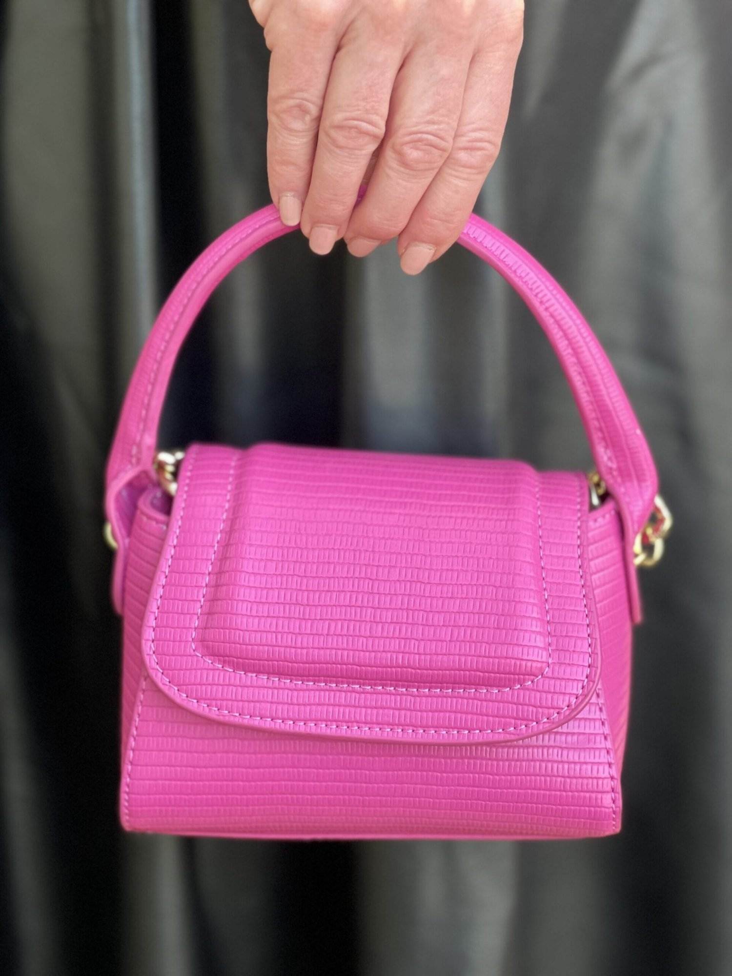 woman holding Scoop Women's Mini Structured Bag in rose violet from Walmart against a black faux leather dress