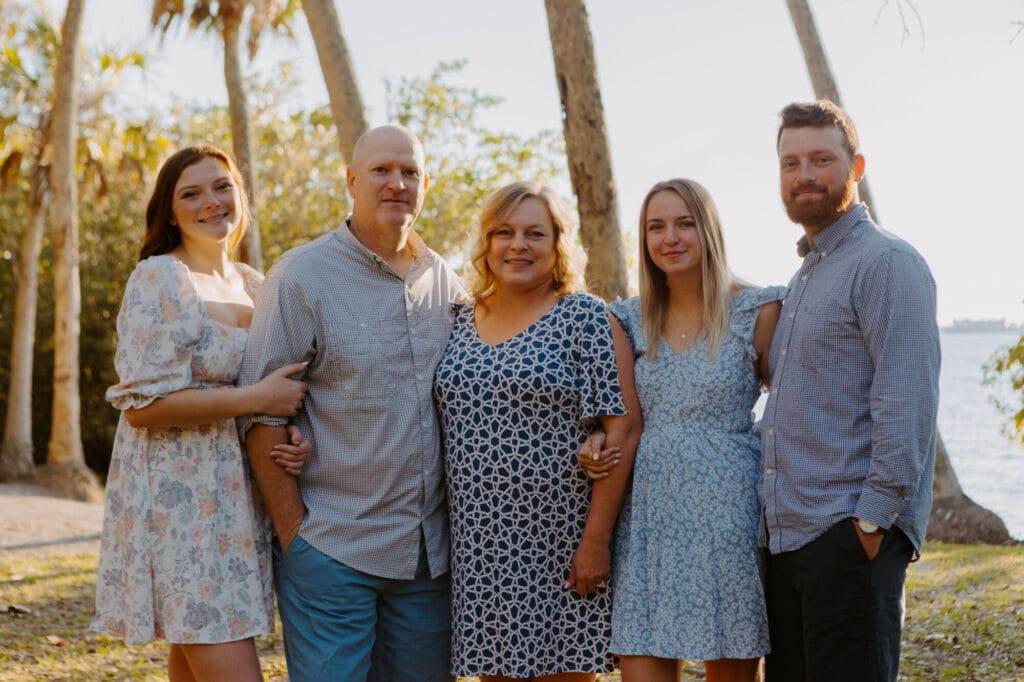 family of five standing next to each other at dusk facing the camera