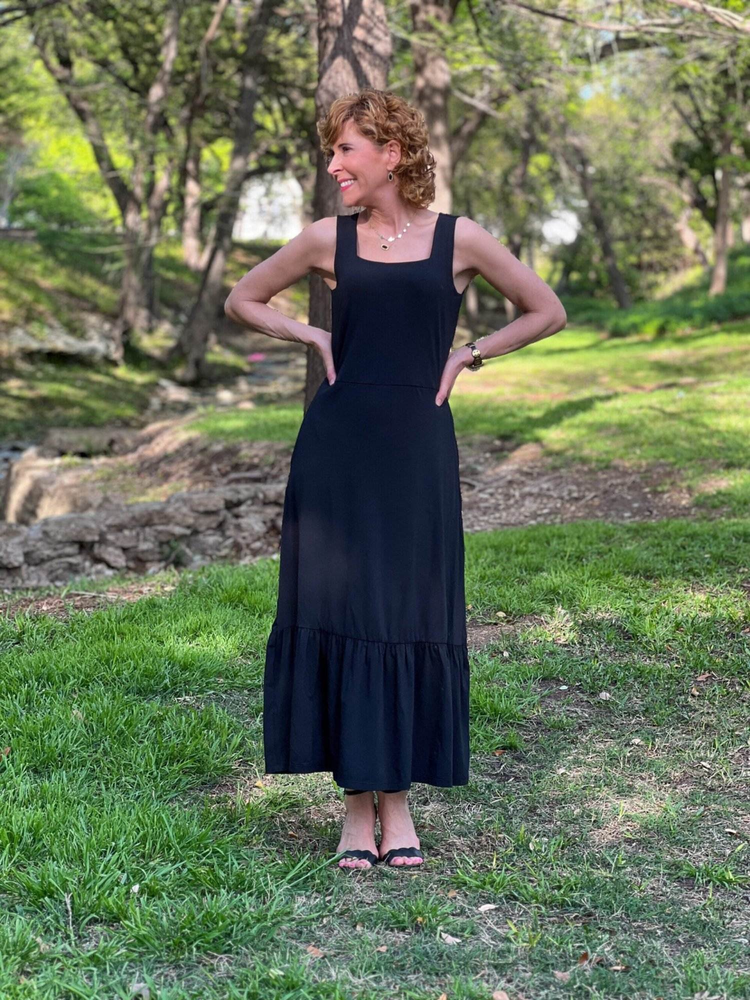 woman with hands on hips looking to the side wearing lands' end black tank dress