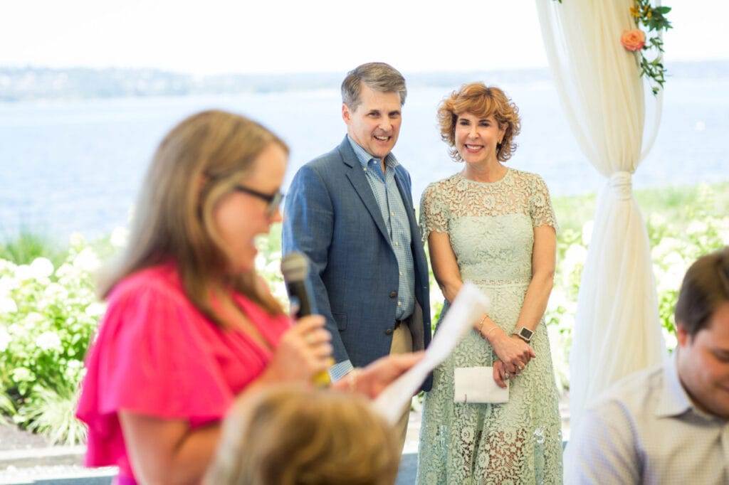 woman giving a toast with couple standing behind her