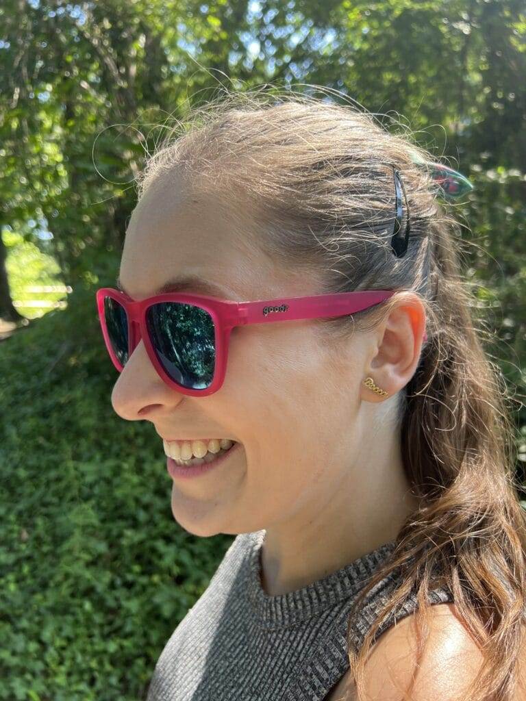 girl with hair in ponytail wearing Goodr OG Sunglasses in color Flamingos On A Booze Cruise